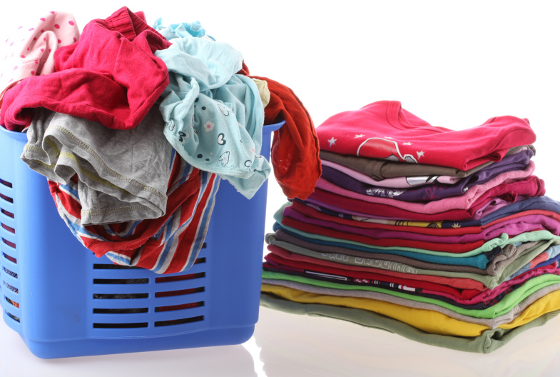 a laundry basket, with a stack of folded clothes next to it